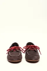 Mocasín tipo boat shoe color marrón, confeccionado en cuero, con cordones de cuero marrón y cordones decorativos azules.