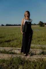 Conjunto de dos piezas compuesto por un top sin mangas con diseño bicolor en blanco y negro y detalle bordado frontal, y un pantalón de corte recto y ancho en color negro con bolsillos laterales y cintura ajustable.