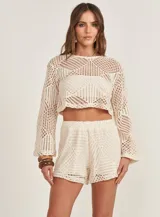 Sweater tejido a crochet color beige, de mangas largas acampanadas y corte crop.