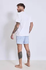 Short de baño azul con estampado floral en tonos rosa y blanco.