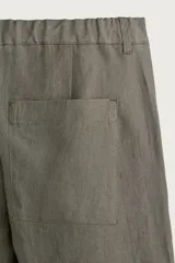 Pantalón straight fit color verde militar, confeccionado en lino, con cintura con trabillas, cierre frontal con cremallera y botón, y bolsillos laterales.