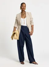 Pantalón de jean azul oscuro de corte palazzo con cintura alta y detalle cruzado en la parte delantera simulando una falda.