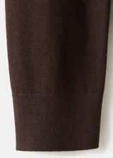 Chaleco de punto fino color marrón, de diseño recto, con cuello en V y sin cierre.