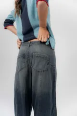 Jean de tiro medio con diseño de pierna amplia y corte holgado, confeccionado en denim azul. Cuenta con bolsillos delanteros y traseros funcionales.
