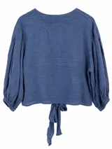 Blusa de lino color azul jean, con escote en V, mangas largas abullonadas con puños elásticos y detalle de nudo en el frente.