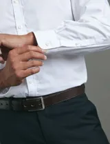 Camisa de vestir de manga larga, confeccionada en popelina fina de algodón, con cuello clásico y cierre frontal de botones.
