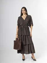 Vestido midi de crepé color marrón, con escote en V, mangas cortas amplias, cintura elastizada con lazo ajustable y falda larga escalonada con volados.