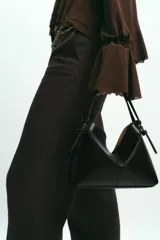 Mini bolso tipo shopper confeccionado en material trenzado color beige, con detalles en cuero sintético marrón. Cuenta con asa de mano fija y correa bandolera extraíble, además de una cartera interior con cierre.