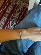 Pulsera dorada con diseño de escamas de serpiente.