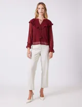 Blusa de encaje color beige, marca Cupio, con cuello a la base y escote en V con lazo de ajuste. Presenta una sobrecapa de encaje con aplique de puntilla y mangas largas de encaje floral translúcido, terminadas en puños elásticos con volado. Incluye forro interno a tono.