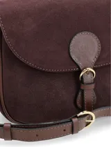 Cartera tipo bandolera de gamuza color bordó, con solapa frontal y detalle de cierre con hebilla decorativa en cuero marrón. Cuenta con correa ajustable y herrajes metálicos dorados.
