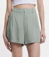 Short de viscosa texturizada color blanco, modelo holgado con cintura de sastrería en la parte delantera, elástico en la parte trasera, trabillas, cierre por botón y cremallera, y bolsillos laterales.