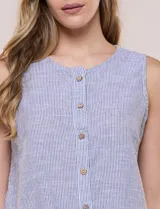 Blusa sin mangas de algodón liviano con diseño de rayas verticales en tonos beige y blanco, escote redondo, abotonadura frontal con botones rústicos y detalle de nudo para anudar en la cintura.