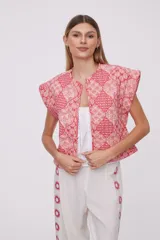 Chaleco corto con estampado geométrico en tonos rosa y rojo, sin mangas y cuello redondo.