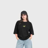 Remera negra de corte oversize y mangas cortas, confeccionada en algodón con pequeño bordado frontal en tono amarillo.