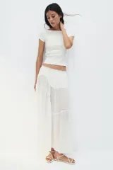 Top corto blanco de punto acanalado, corte ajustado, con mangas cortas y escote bote.