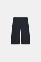 Bermuda larga de tiro medio, color azul marino con finas rayas diplomáticas blancas. Presenta cintura con trabillas, bolsillos laterales ocultos en costura y cierre frontal con cremallera, botón y ganchos metálicos.