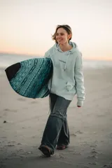 Hoodie celestes con capucha y diseño gráfico en la espalda que incluye delfines, el texto "GW" y "Glassy Waves" sobre una ola.