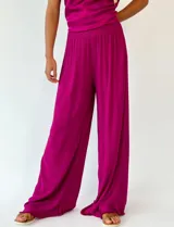 Pantalón fucsia de corte palazzo y textura plisada.