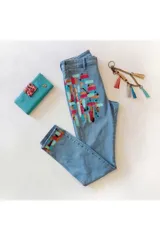 Jean de denim celeste con diseño pintado a mano de estilo abstracto en colores multicolor.