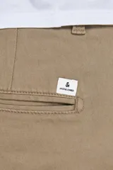 Pantalón chino color beige con cierre de cremallera.