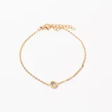 Pulsera dorada con cadena fina y dije circular con una circonita blanca engarzada.