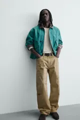 Pantalón straight fit de algodón con efecto lavado y roturas localizadas. Presenta diseño de cinco bolsillos, cierre frontal con cremallera y botón metálico.