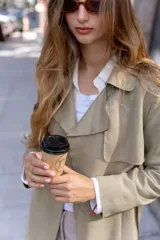 Trench largo de gamuza en color beige, con solapas amplias, diseño abierto y corte recto.