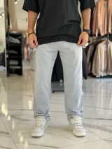 Pantalón de jogging gris melange, con diseño oversize y corte recto, ideal para un estilo urbano y cómodo.