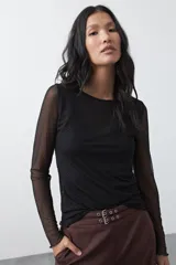 Top de manga larga confeccionado en tejido translúcido con micro textura de puntos, de silueta ajustada y diseño liviano.