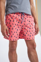 Short de baño con cintura elástica y cordón ajustable, confeccionado en tela ligera de secado rápido. Presenta un estampado botánico integral en tonos amarillos, blancos y azules, con dos bolsillos delanteros y uno posterior.