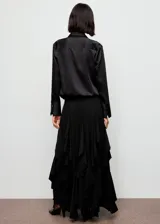 Camisa de mujer con acabado satinado, diseño recto, cuello camisero, manga larga con puños abotonados y cierre frontal con botones.