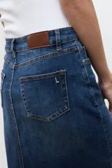 Falda midi de jean de corte recto y tiro medio, en tono azul medio con ligero efecto lavado y tajo frontal sutil.