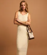 Vestido midi de punto texturizado color beige, sin mangas y con cuello redondo.
