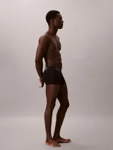 Pack de tres boxers ajustados de corte trunk marca Calvin Klein, modelo Intense Power. Confeccionados en mezcla de algodón y elastano de color negro, cuentan con una llamativa cinturilla elástica distintiva con el logotipo de la marca en colores gris, azul y blanco.