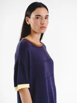 Vestido midi de punto de manga corta con detalles calados y diseño de rayas horizontales tricolor en la parte inferior. Presenta cuello redondo y logo bordado en el pecho.