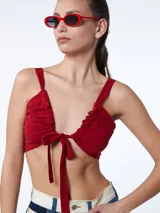 Top rojo con breteles finos y escote fruncido con lazo ajustable en el centro.