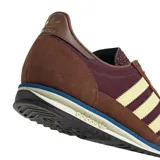 Championes Adidas SL 72 OG de color marrón, con las clásicas tres tiras laterales en tono amarillo claro y detalles en azul y blanco en la suela.