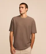 Remera de corte relajado, color marrón topo, con cuello redondo y mangas cortas. Presenta una textura acanalada fina en toda la prenda.