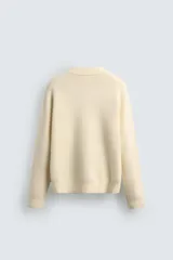 Jersey de punto con textura efecto pelo, corte relajado, cuello redondo y manga larga con acabados en rib.