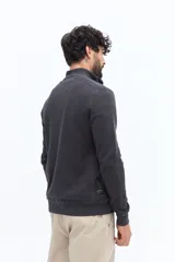 Buzo de algodón color azul marino con medio cierre frontal y cuello alto. Presenta un pequeño logo bordado en el pecho.