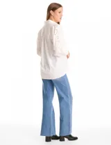 Camisa de color rosado con cuello clásico y cierre frontal de botones. Presenta mangas largas con detalles calados y puños anchos abotonados.