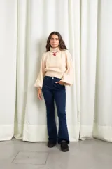 Jean de corte flare oxford, color azul oscuro, con tiro alto y cierre frontal con botón metálico.