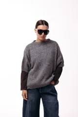 Sweater de tejido de punto grueso con silueta amplia y mangas 3/4. Presenta un diseño de calce relajado con cuello redondo y textura voluminosa.