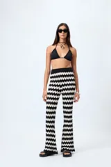 Pantalón tejido con motivo zigzag en blanco y negro, de corte flare y cintura elastizada.