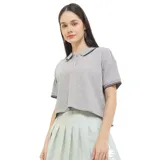 Remera tipo polo de manga corta Converse, color gris con textura waffle. Presenta cuello camisero con ribetes negros, cierre frontal con botones y bordado sutil en el pecho.
