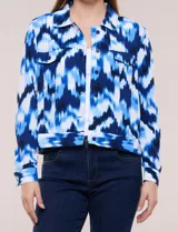 Camperita liviana de silueta entallada con estampado abstracto en tonos de azul y blanco, cuello camisero, cierre frontal con botones, bolsillos en el pecho con solapa y mangas largas.