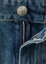 Jeans de tiro medio confeccionados en tejido de algodón estilo vaquero, con diseño balloon y corte ancho, cierre de botón y cremallera, trabillas y cinco bolsillos.