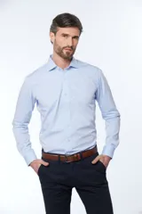 Camisa celeste entallada de manga larga con cuello clásico y cierre frontal con botones. Pantalón de vestir azul marino con cinturón de cuero marrón.