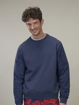 Buzo de cuello redondo con cuerpo de algodón y mangas de nylon acolchadas con diseño capitoné. Presenta un bolsillo pequeño con cierre en una de las mangas y puños elásticos.